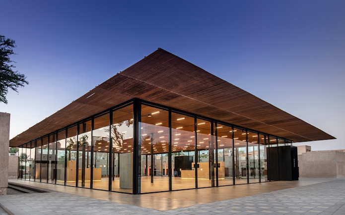 Modern glass building of Al Shindagha Museum in Dubai at dusk.