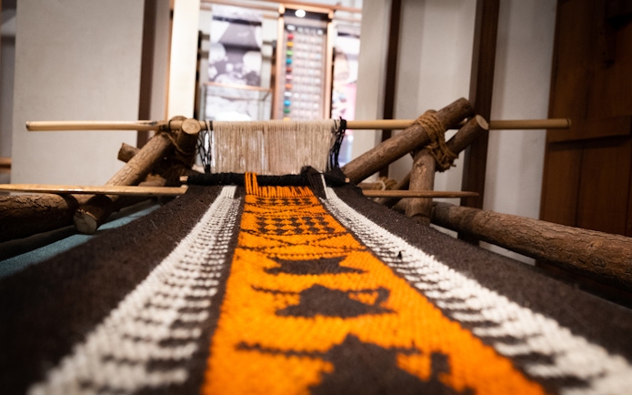 Traditional loom with colorful woven fabric at Al Shindagha Museum, Dubai.