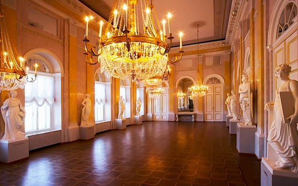 Chandeliers and statues in a grand hall at Albertina Museum, Vienna.