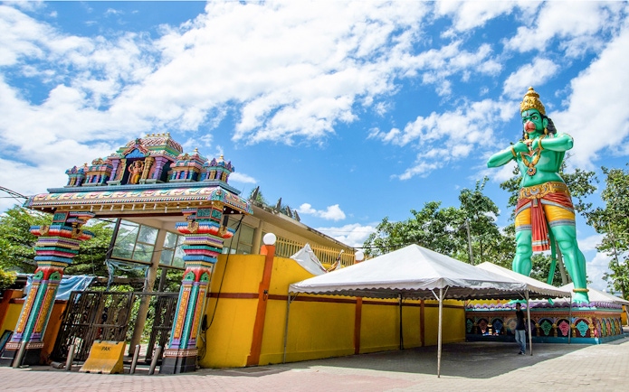 Colorful entrance and large statue at Batu Caves, Malaysia, on a day tour.