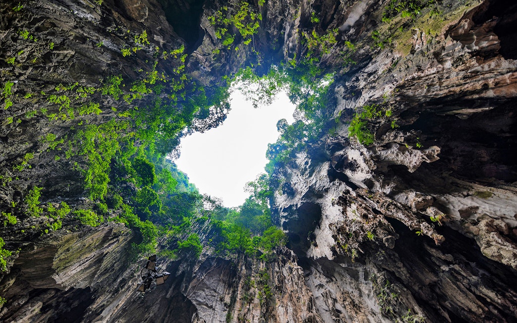 View of Batu Caves' limestone formations with greenery, Malaysia.