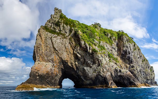 Rock formation with arch in Bay of Islands, New Zealand, viewed from the water.