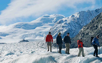 Group hiking on a glacier with Mt Cook in the background, New Zealand.