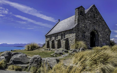 Stone church near Lake Tekapo with mountain backdrop on Mt Cook tour from Christchurch.