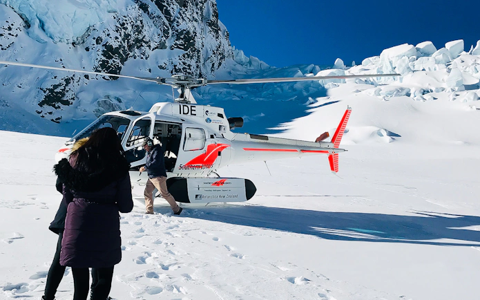 Helicopter landing on snowy terrain during Mt Cook tour from Christchurch.