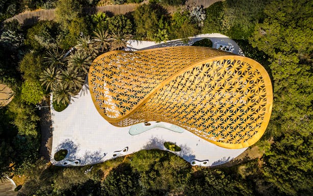 Aerial view of Al Noor Island's golden pavilion surrounded by lush greenery in Sharjah.
