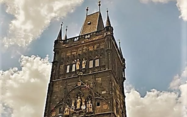 Charles Bridge Tower against a cloudy sky in Prague.