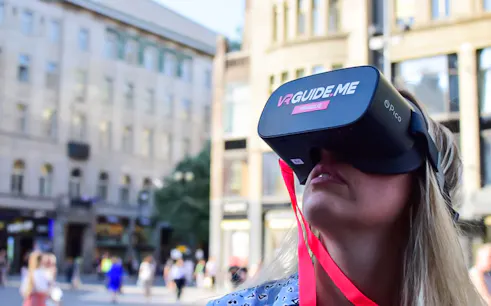 Person using VR headset on Charles Bridge tour in Prague.