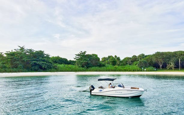 Speedboat cruising near lush greenery on Sentosa's Southern Islands.
