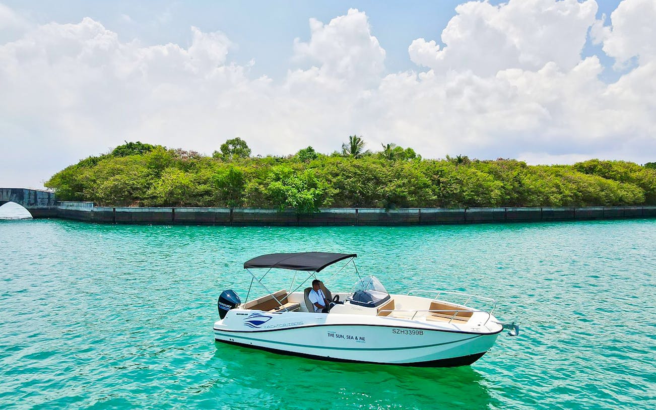 Speedboat cruising near lush greenery on Sentosa's Southern Islands.
