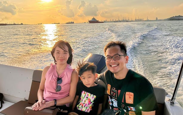 Family enjoying a sunset speedboat tour near Sentosa, Singapore.