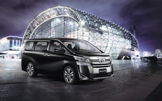 Changi Airport transfer vehicle in front of modern glass building in Singapore.