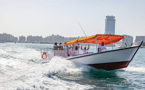 Private boat cruising near Dubai skyline during small group discovery tour.