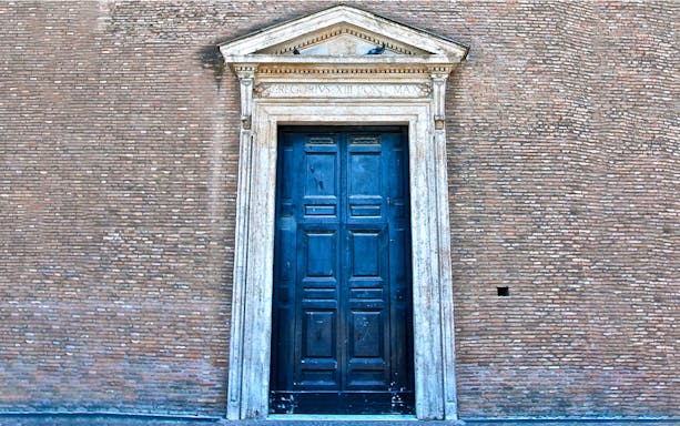 Doorway of Lateran Complex in Rome, featuring ornate stonework and historical inscriptions.