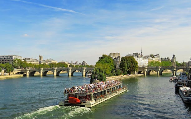 Seine River cruise near Pont Neuf, Paris, part of Musée d'Orsay tour.