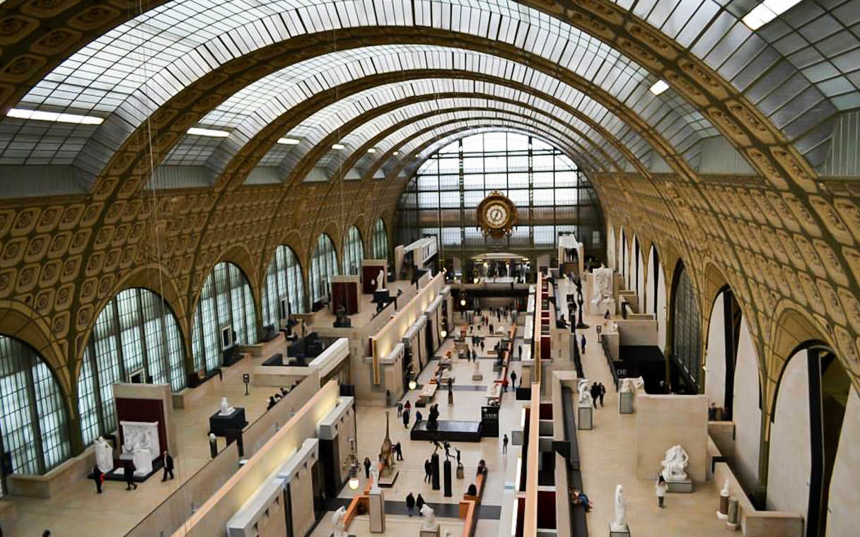 Interior view of Musée d'Orsay with sculptures and iconic clock during entry and mini walking tour.