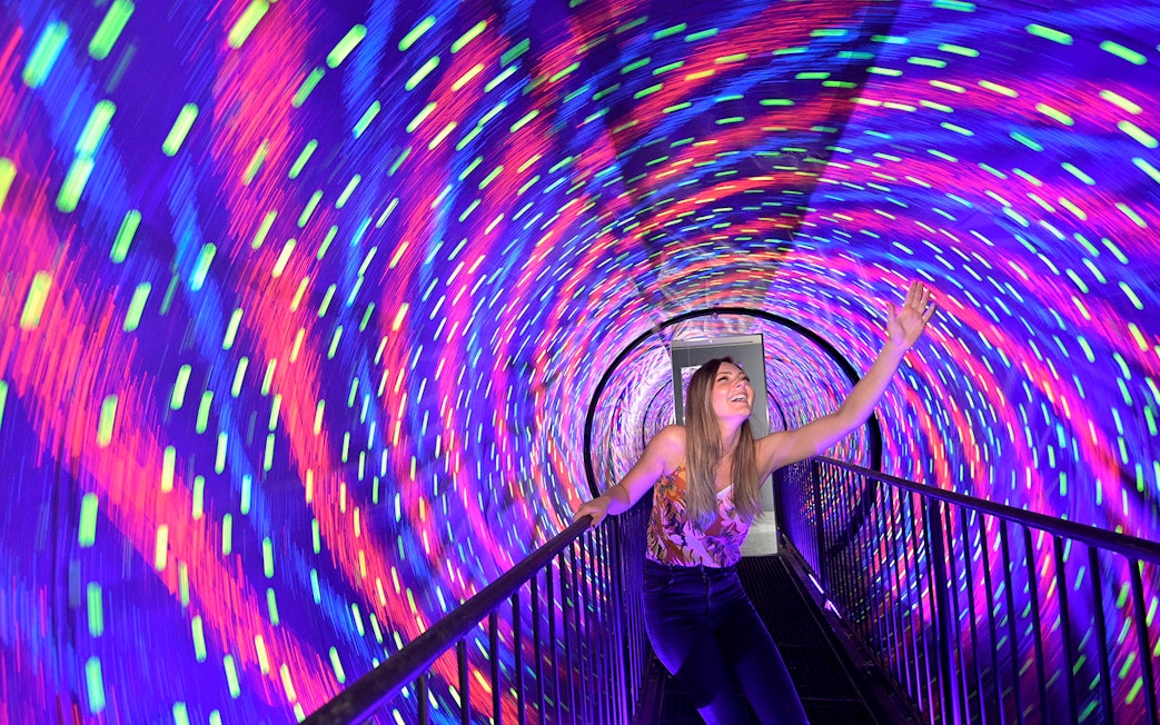 Visitor enjoying colorful vortex tunnel at Museum of Illusions Kuala Lumpur.