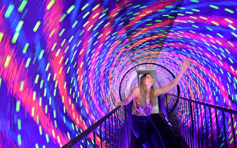 Visitor enjoying colorful vortex tunnel at Museum of Illusions Kuala Lumpur.