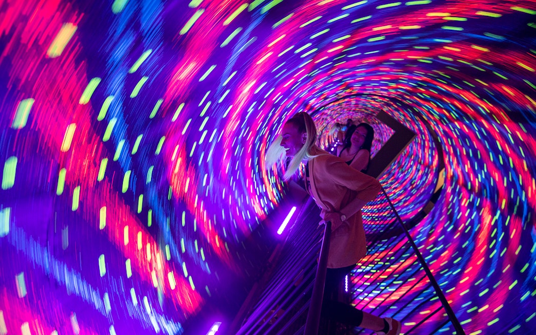 Visitors in a colorful vortex tunnel at Museum of Illusions Kuala Lumpur.