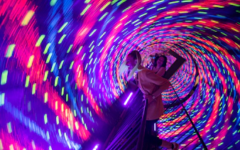 Visitors in a colorful vortex tunnel at Museum of Illusions Kuala Lumpur.