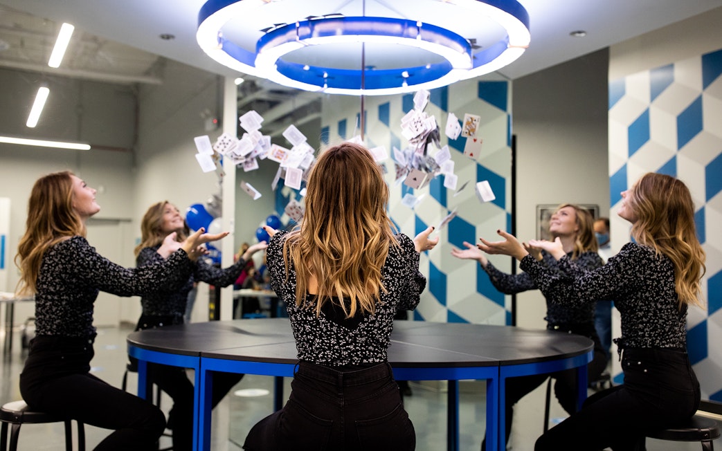 Visitors experiencing optical illusion with mirrors and cards at Museum of Illusions Kuala Lumpur.