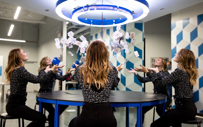 Visitors experiencing optical illusion with mirrors and cards at Museum of Illusions Kuala Lumpur.