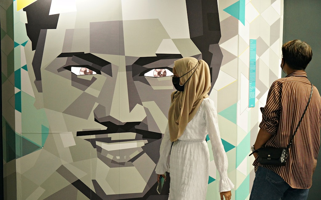Visitors observing geometric face art at Museum of Illusions Kuala Lumpur.