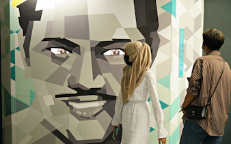 Visitors observing geometric face art at Museum of Illusions Kuala Lumpur.