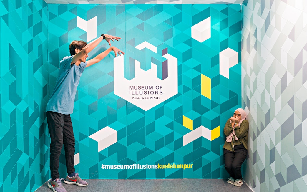 Visitors interacting with an illusion at the Museum of Illusions Kuala Lumpur.