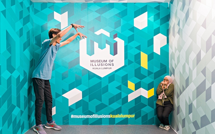Visitors interacting with an illusion at the Museum of Illusions Kuala Lumpur.