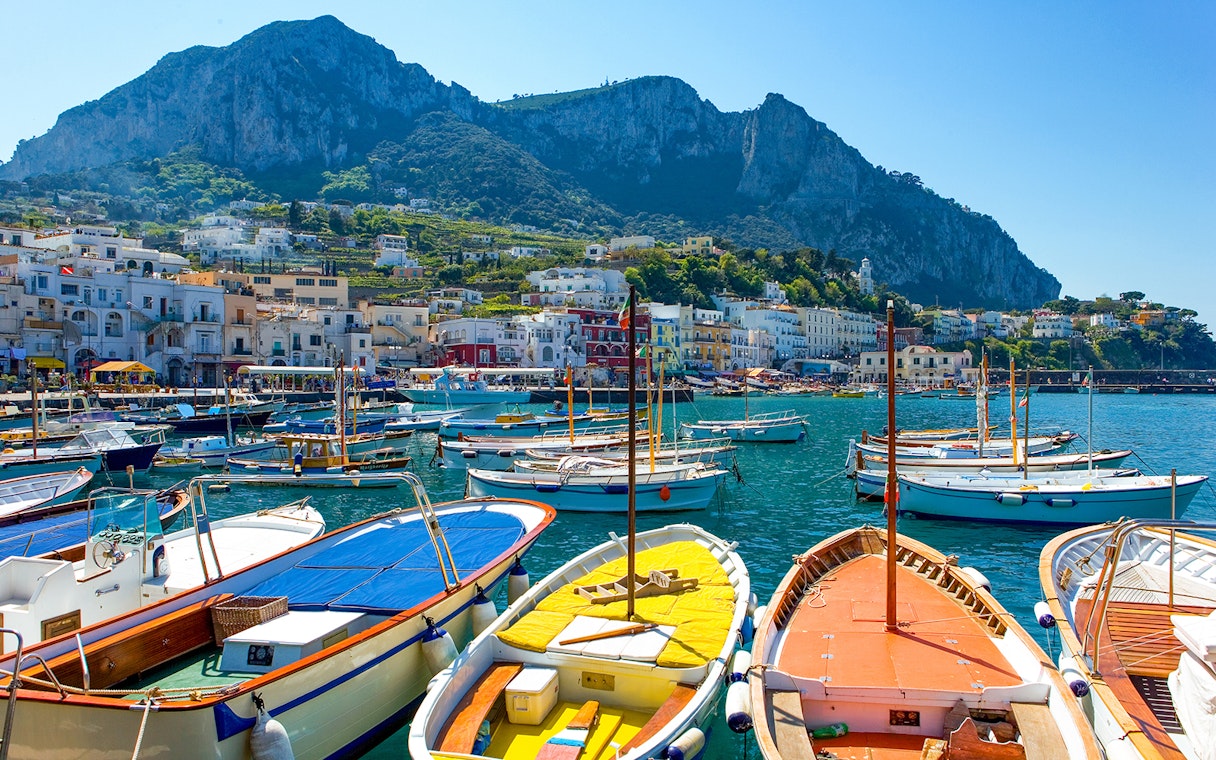 Boats docked at Marina Grande with Capri's cliffs in the background, Island of Capri.