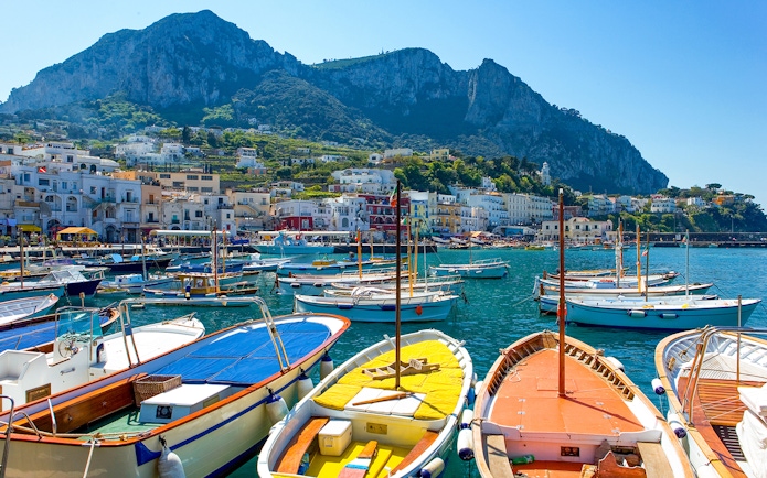 Boats docked at Marina Grande with Capri's cliffs in the background, Island of Capri.