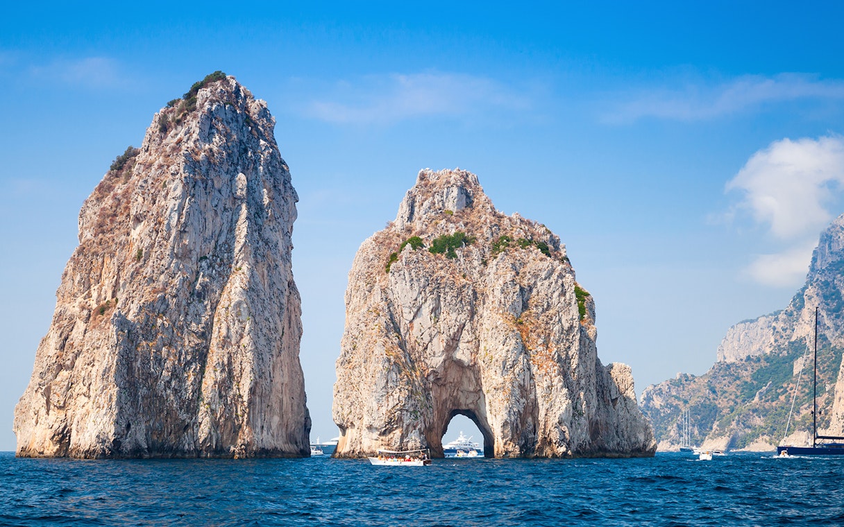 Faraglioni rock formations in Capri, Italy, viewed from the sea during a boat tour.