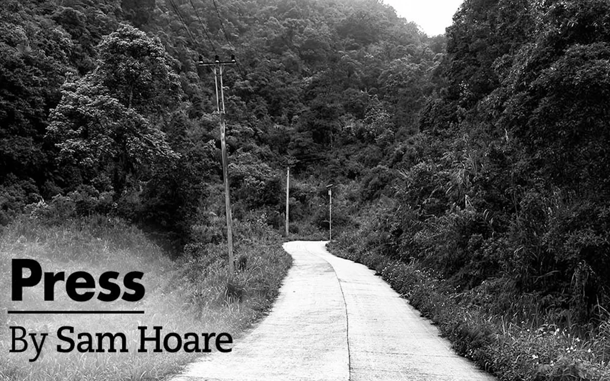 Winding road through dense forest with power lines, titled "Press" by Sam Hoare.