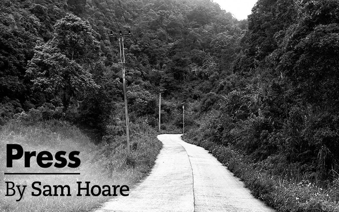 Winding road through dense forest with power lines, titled "Press" by Sam Hoare.