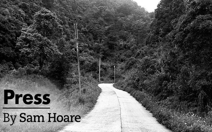 Winding road through dense forest with power lines, titled "Press" by Sam Hoare.