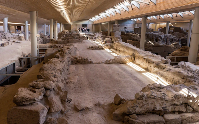 Akrotiri archaeological site interior with ancient ruins and walkways.