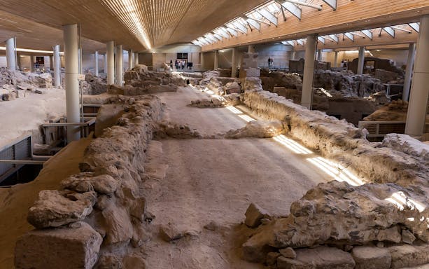 Akrotiri archaeological site interior with ancient ruins and walkways.
