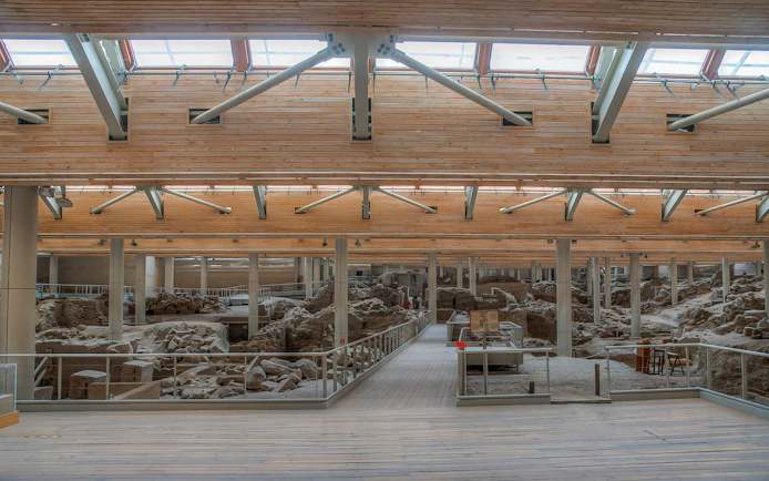 Akrotiri archaeological site interior with ancient ruins and walkways.