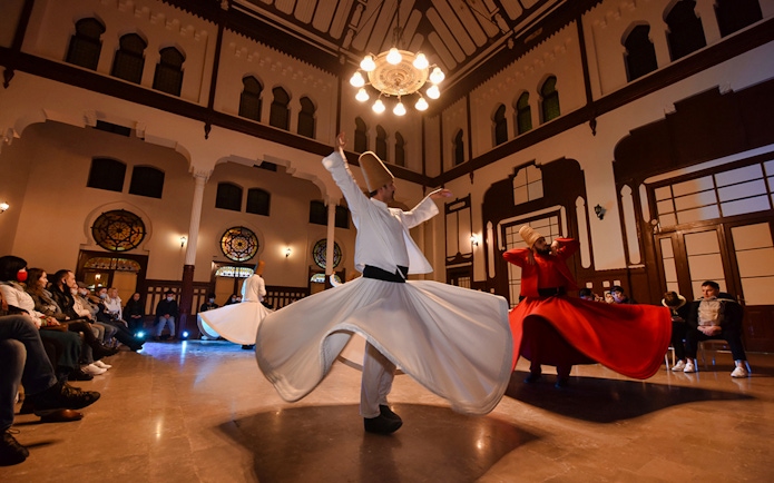 Whirling dervishes performing in a traditional ceremony hall, Istanbul.