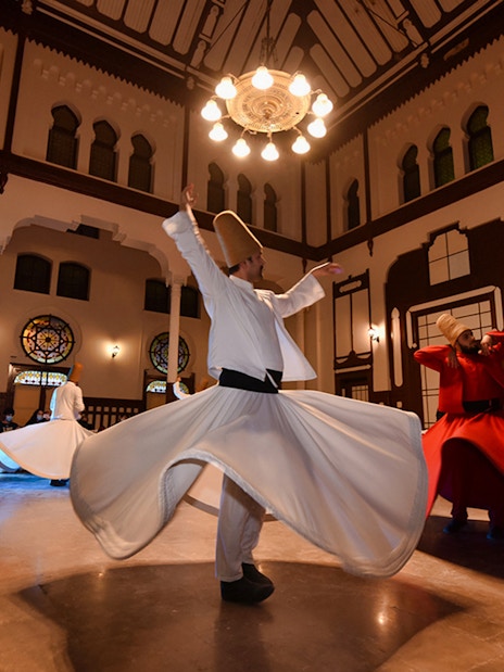 Whirling dervishes performing in a traditional ceremony hall, Istanbul.