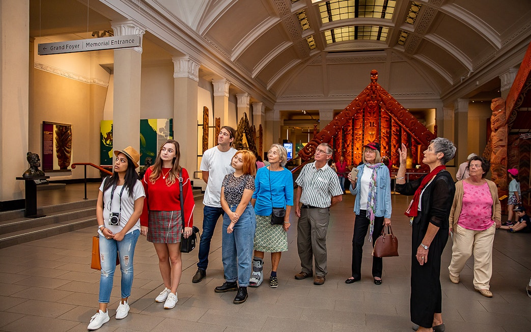 Visitors exploring the Auckland War Memorial Museum with a guide.
