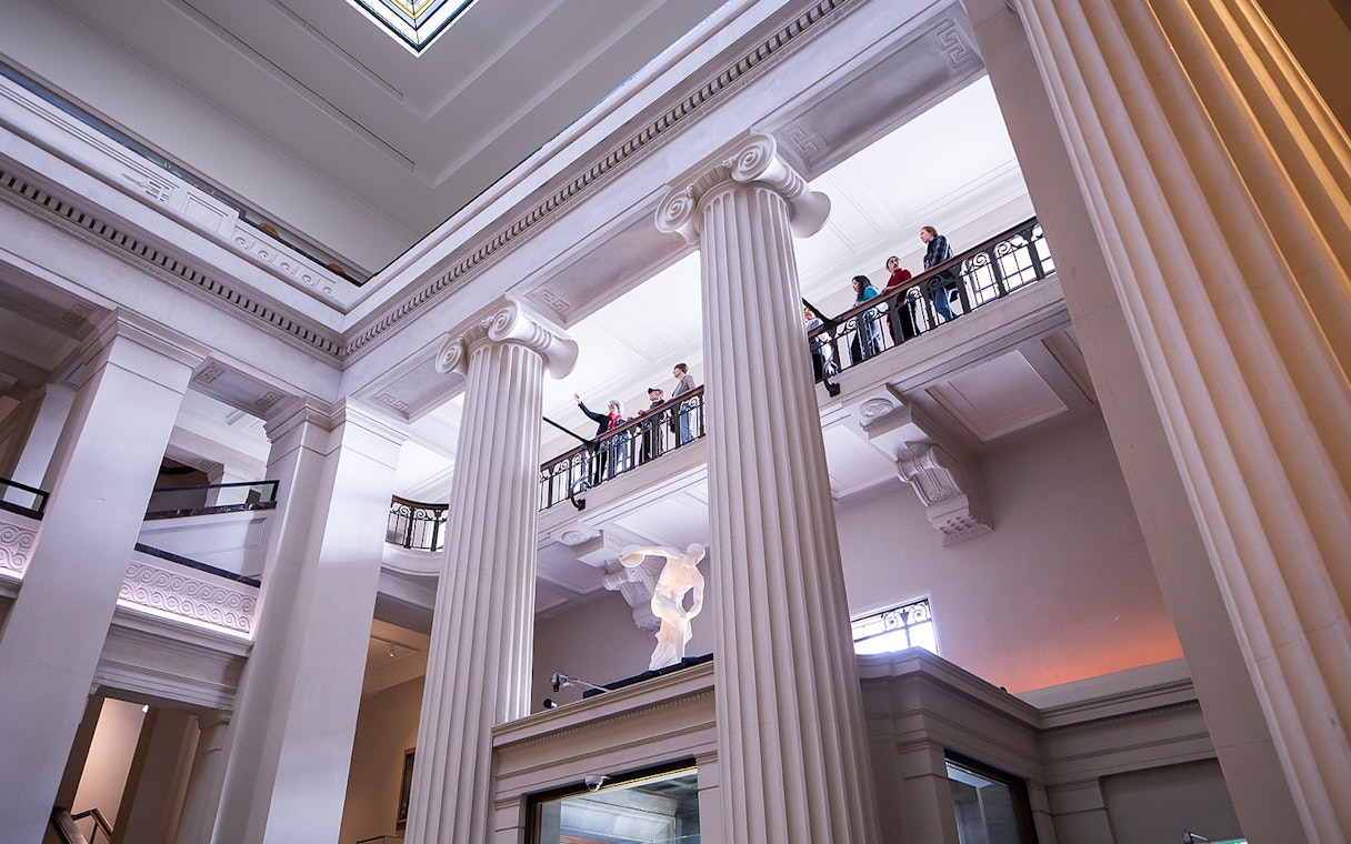 Auckland War Memorial Museum interior with visitors on upper balcony.