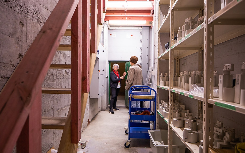 Auckland War Memorial Museum staff discussing exhibits in a storage area.