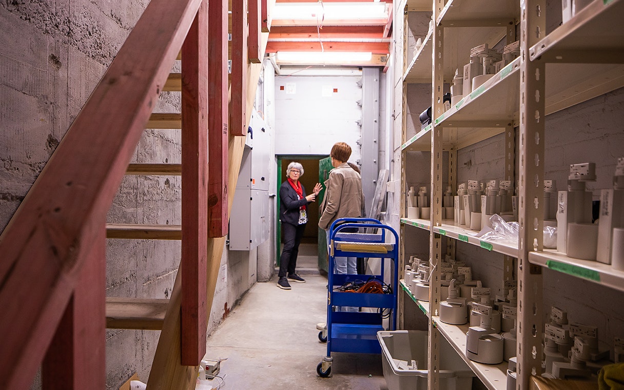 Auckland War Memorial Museum staff discussing exhibits in a storage area.