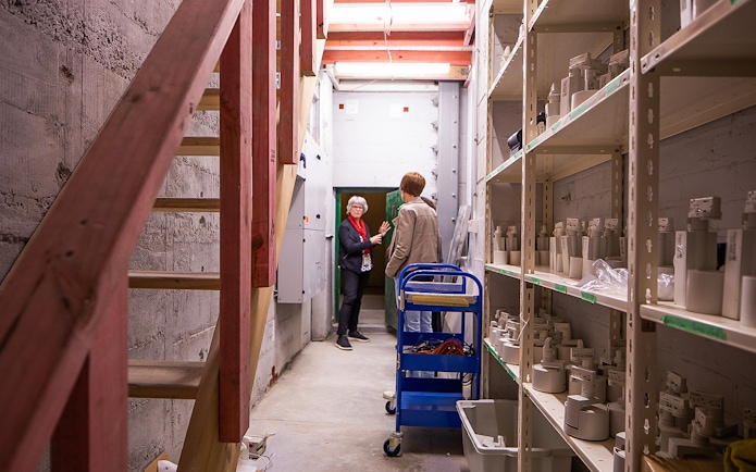 Auckland War Memorial Museum staff discussing exhibits in a storage area.