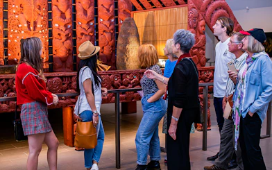 Visitors observing Maori carvings at Auckland War Memorial Museum.