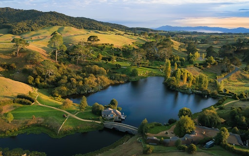 Hobbiton Movie Set landscape with lake and hills, viewed from Rotorua tour.