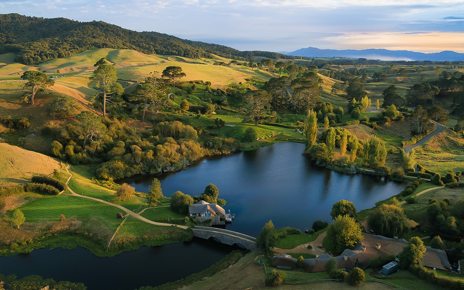 Hobbiton Movie Set landscape with lake and hills, viewed from Rotorua tour.