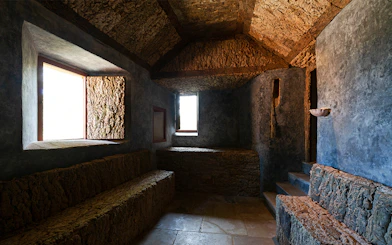Convento dos Capuchos interior with stone benches and rustic walls, Sintra, Portugal.